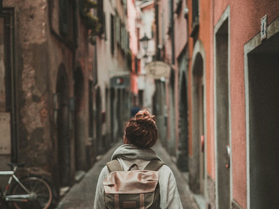 Traveller with a backpack walking down an old town street