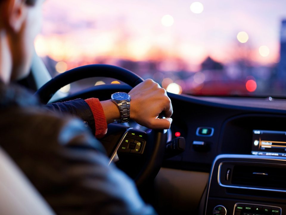 Driver at the wheel of a rental car at dusk