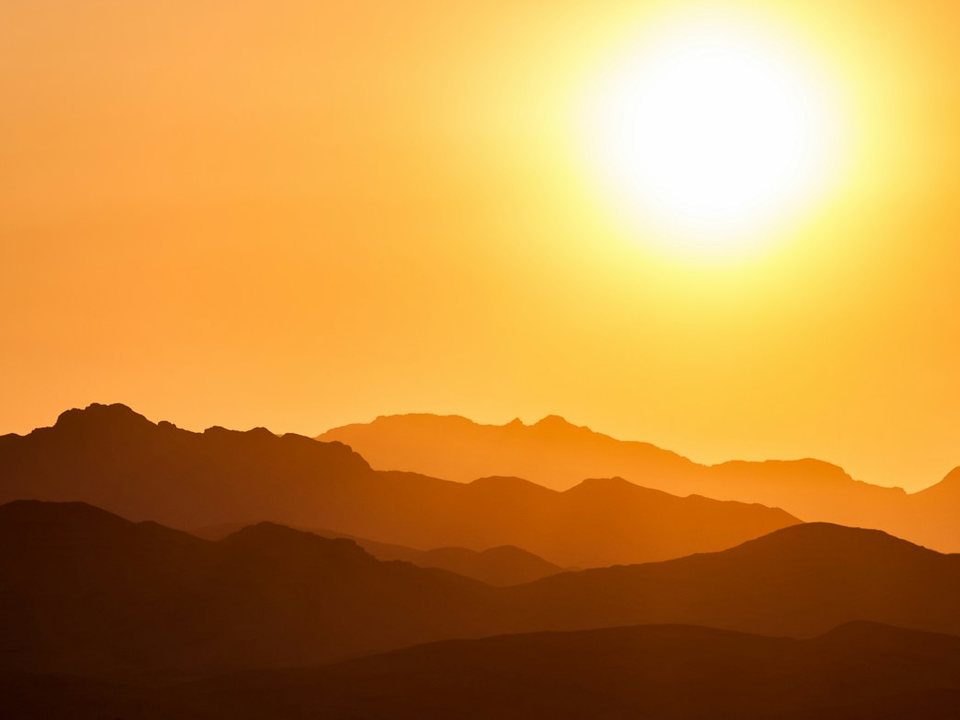 Sun setting over mountains at a travel destination